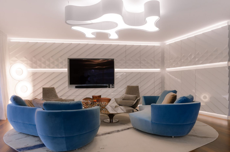 Paris 56 Fine Interiors with Fine Rugs; Apartment Genf / Schweiz living room with two blue sofas and 2 beige/grey armchairs, a glass center table, and a beautiful rig underneath.