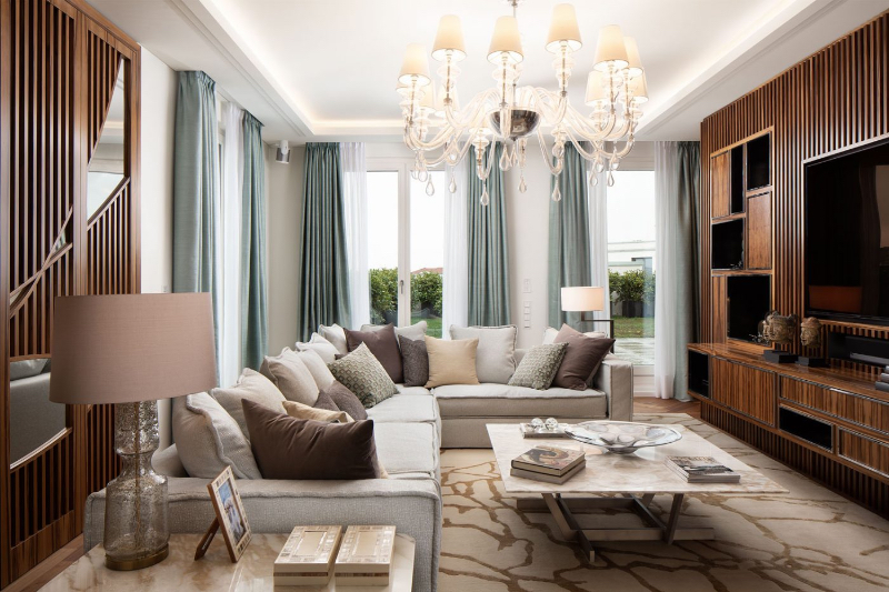 Paris 56 Fine Interiors with Fine Rugs; Penthouse Kurfürstenstraße living room with a stunning rug, a sofa, a classic chandelier and a wooden display, it also has a glass center table.
