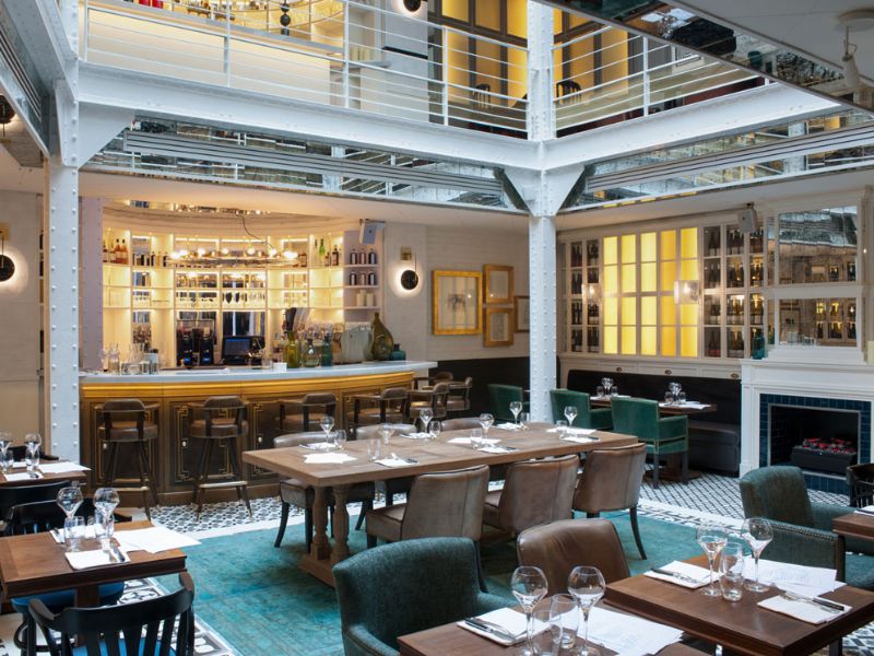 hotel dining room with upholstered dining chairs, wooden dining tables and decorative elements
