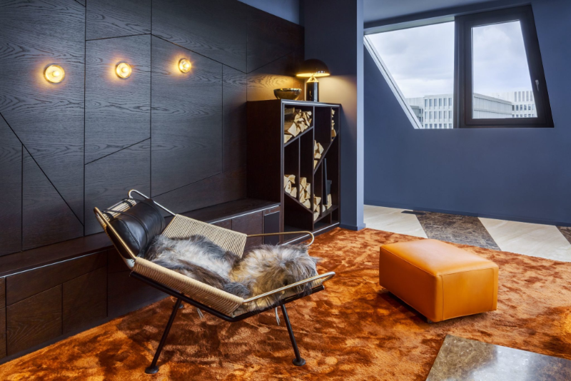 PENTHOUSE 105 reading corner with an orange stool, a terracotta rug and an armchair. The perfect inspiration for modern rug designs.