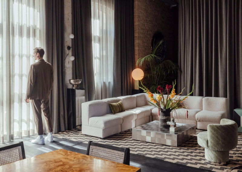 Suite/ showroom project from fabian Freytag with a white corner sofa, a green armchair and  modern rug designs