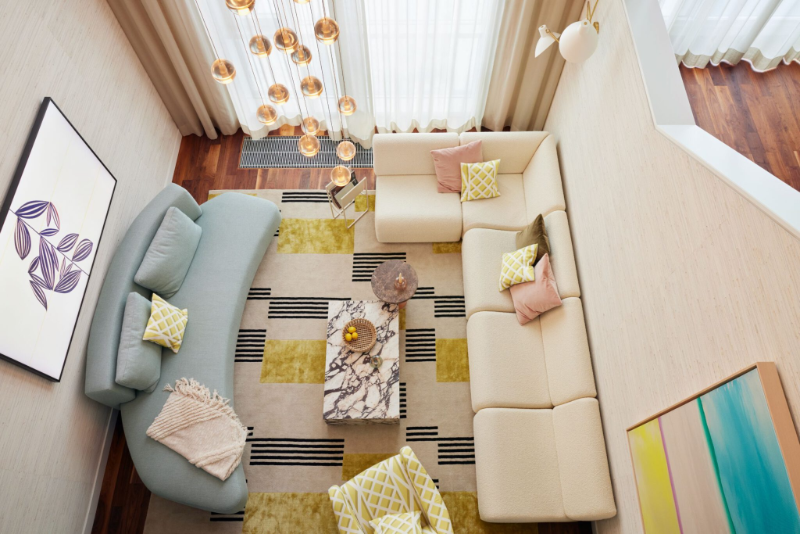 TOWNHOUSE 21 overviews of geometric modern rug designs, 1 square withe couch, one round baby blue couch, one marble center table, one yellow armchair, and some pendant lights.