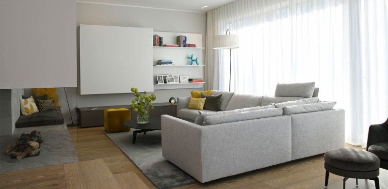 Gabriela Raible Innenarchitektur, family living room with a white/grey sofa, a grey rug and some yellow details.