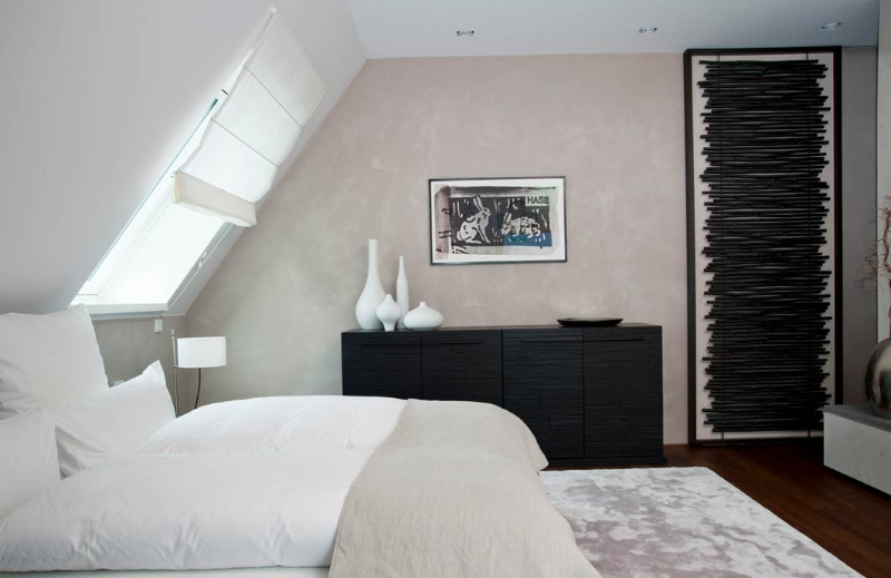 Gabriela Raible Innenarchitektur lakeside villa bedroom with a white bed, a white area rug, and some wood furniture.