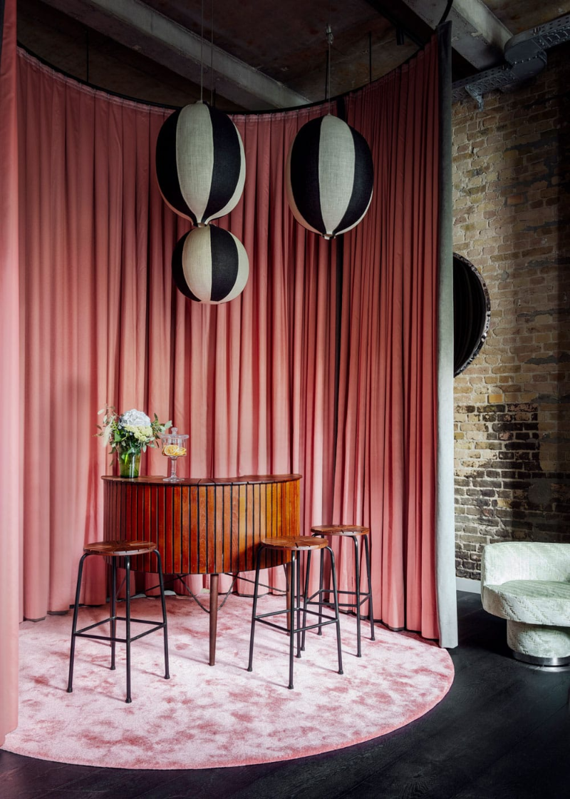 Suite modern rug designs with a fluffy pink round rug under a bar and some bar stools.