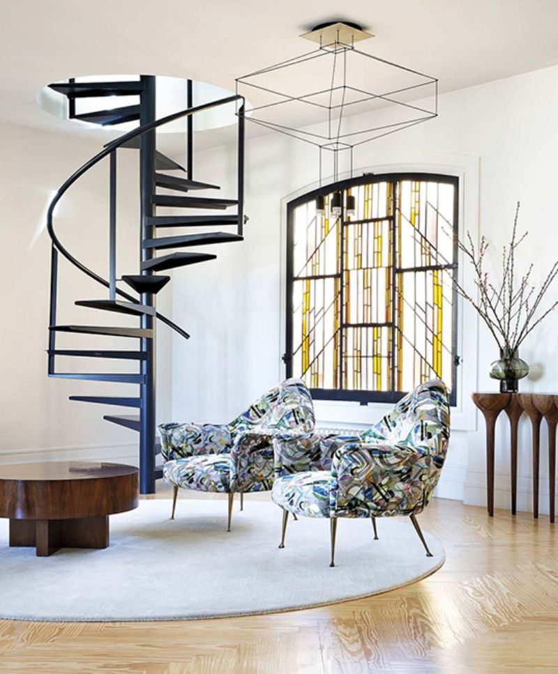 living room by ines benavides with colorful armchairs, white round rug and brown coffee table