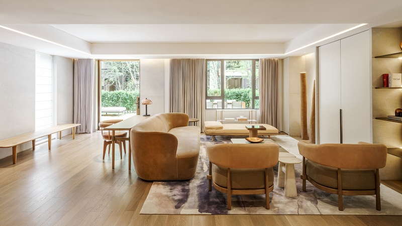 Rug designs from Mason Studio. This living room has light orange sofa and two armchairs, a violet and white rug and white coffee table.