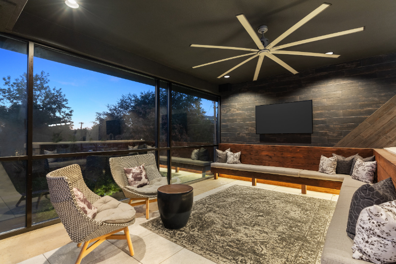 Rug Design Inspiration From Faulkner Design Group. A wide living room with a huge sofa integrated on the walls, two armchairs and a rug in the middle.