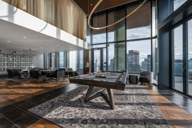 Rug Design Inspiration From Faulkner Design Group. This is a living area, there's a big rug with a pool table over it.