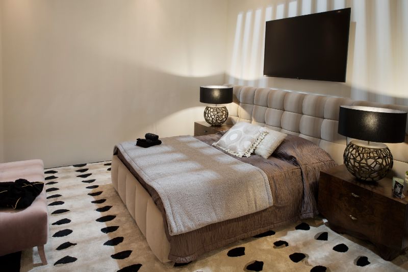 A meutral and minimalistic bedroom decor at Salone Del Mobile with gray rug with black flower design