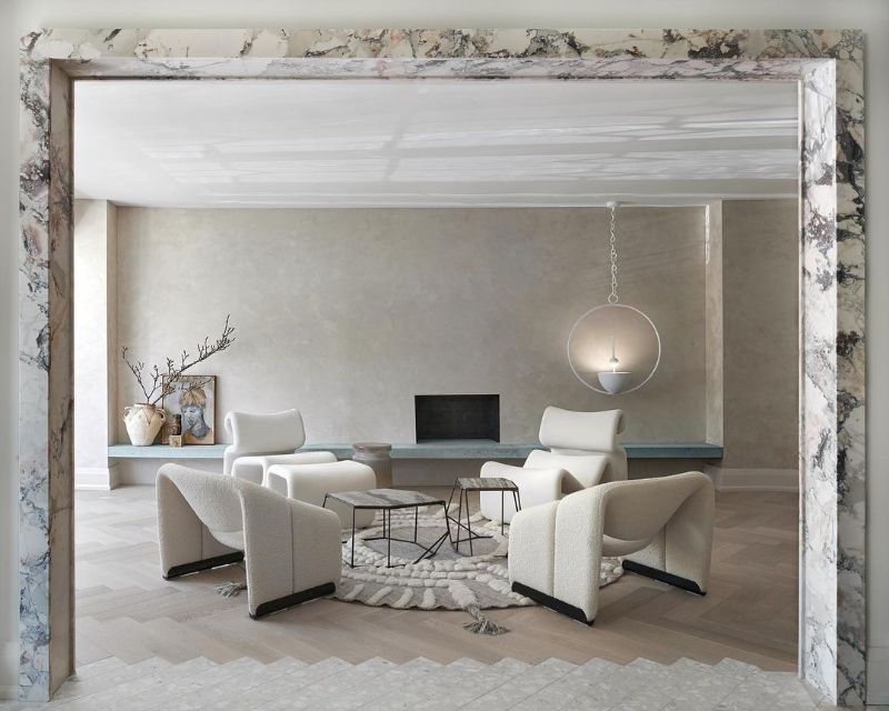 Maxine Tissenbaum And The Art of Bespoke Interior Designs. Contemporary living room with round rug in gray hues and white armchairs.