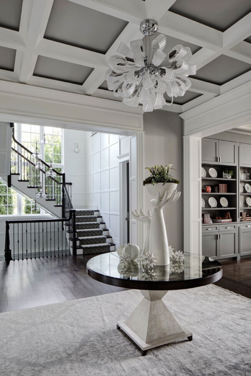 Hallway interior design featuring a center table with a sculpture and a neutral rug