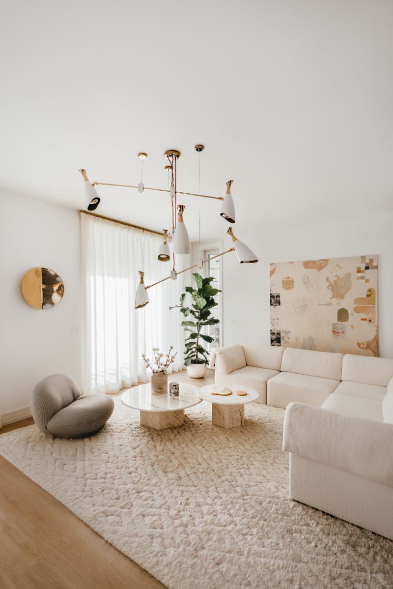 White living room with white area rug, white hanging lights and white sofa
