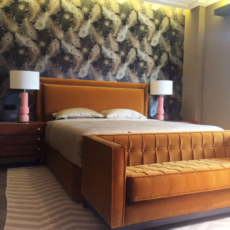 orange bed headboard, brown side tables, white and pink lamps, orange sofa
