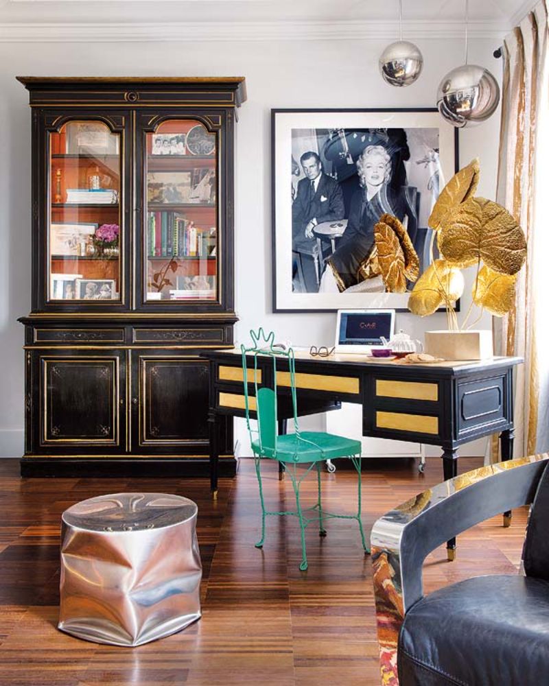 black library, pictures, golden decorative elements, black desk, green chair
