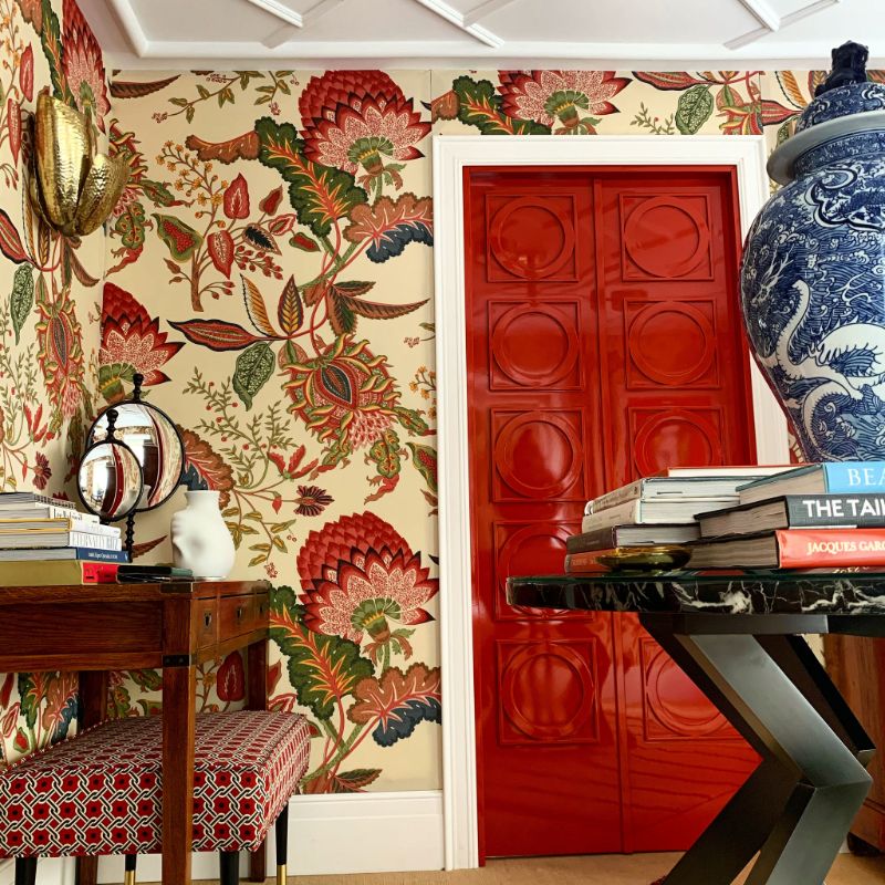 floral wallpaper, red bench, brown table, decorative books