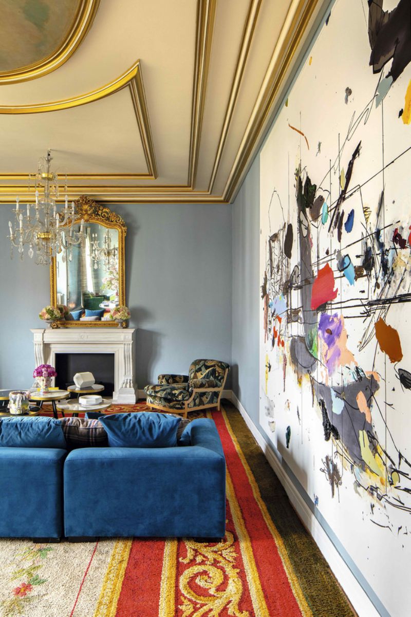 abstract painting, blue sofa, white fireplace
