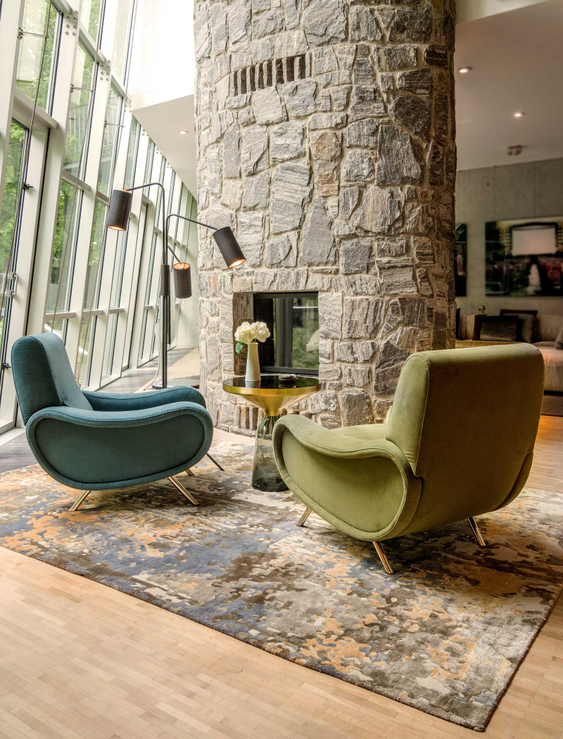 Raumkonzepte Peter Buchberger, Architektenvilla reading corner with a fireplace, 2 armchairs, a green and a blue one, as well as a fun blue rug underneath