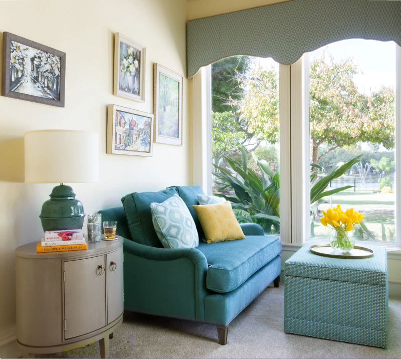Rug Design Inspiration by Karen Davis. A living room with a blue table light and a blue sofa and ottoman.