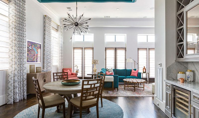 Rug Design Ideas From Pamela Hope Designs. A open-space dining room next to the living room, the round table and the chairs are over a round rug.