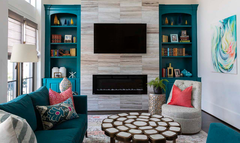 Rug Design Ideas From Pamela Hope Designs. In this living room there is a light-colored rug, a blue sofa and a beige single sofa.