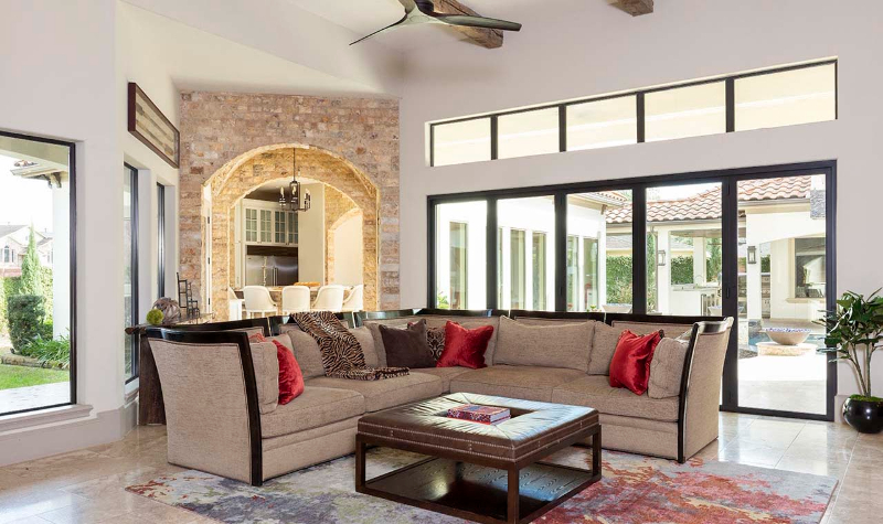 Rug Design Ideas From Pamela Hope Designs. A L-shaped sofa with a square center table on a colorful rug.