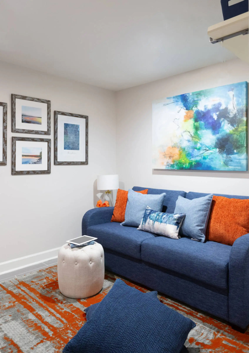 Rug Design Inspiration by Karen Davis. This colorful rug matches the pillows on the blue sofa.