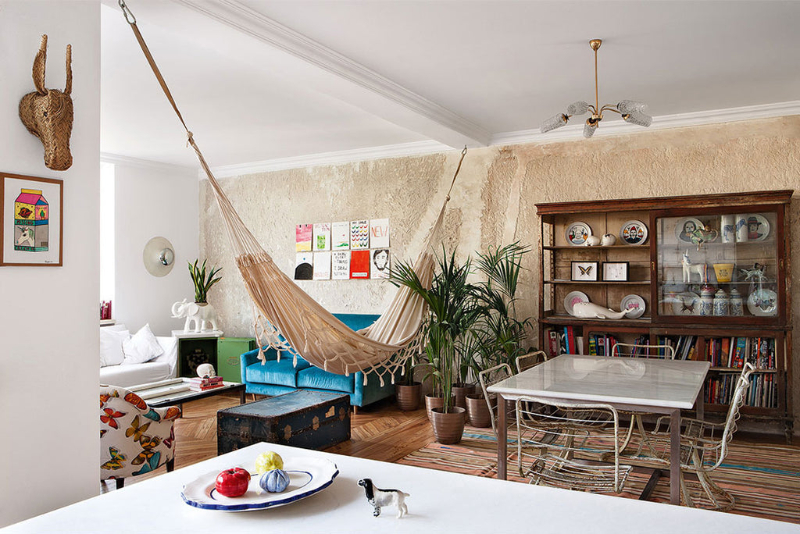 living room and dining room by Guille García Hoz with white table and chairs, blue sofa, white hamrock and decorative elements