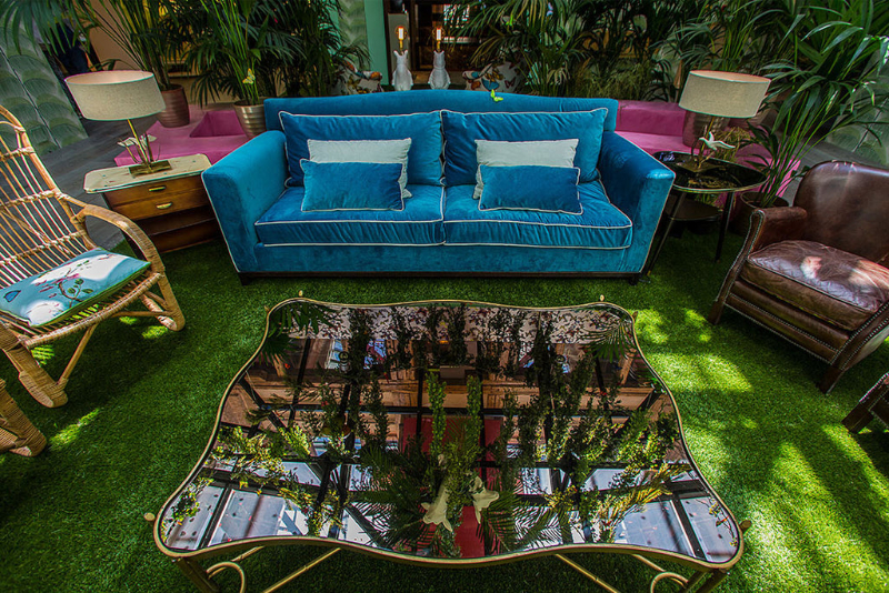 living room by Guille García Hoz with green carpet, glass center table, blue sofa and leather armchairs