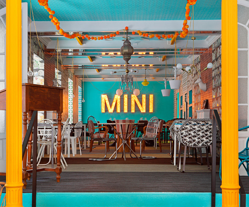 restaurant by Guille García Hoz with white, black and metallic chairs and colorful decorative elements